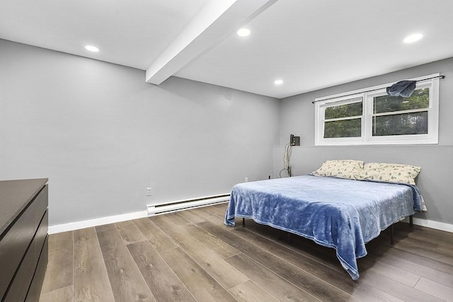 bedroom featuring baseboard heating, wood finished floors, baseboards, recessed lighting, and beamed ceiling