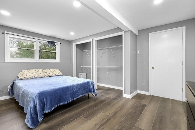 bedroom with wood finished floors, recessed lighting, baseboards, and two closets