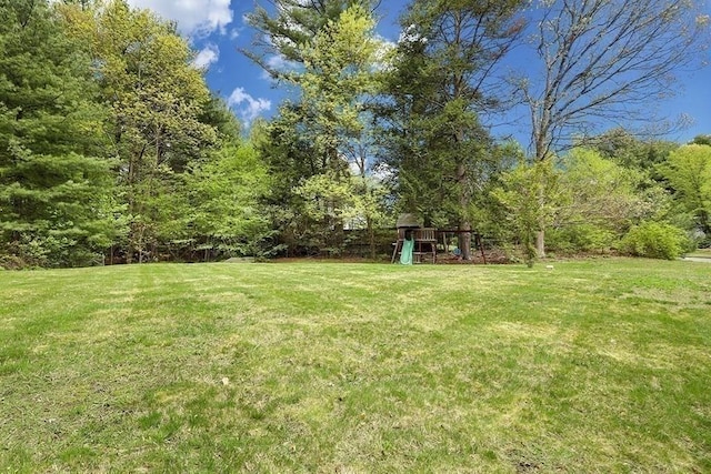 view of grassy yard featuring a playground