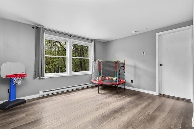 sitting room featuring baseboard heating, wood finished floors, and baseboards