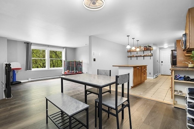 dining space featuring wood finished floors, a baseboard heating unit, and baseboard heating