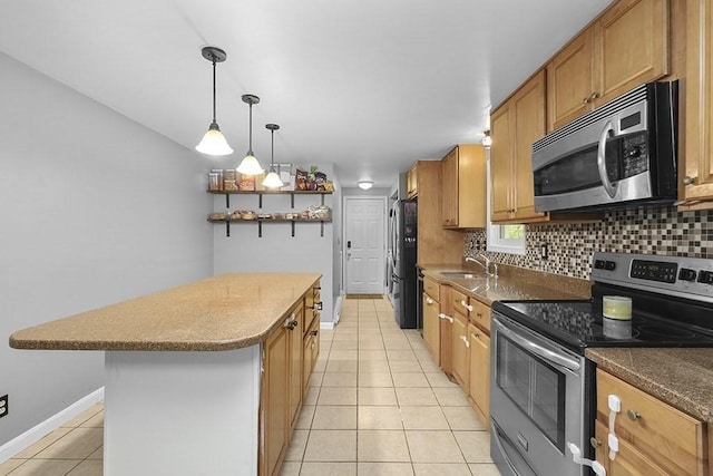 kitchen with appliances with stainless steel finishes, light tile patterned floors, a center island, backsplash, and baseboards