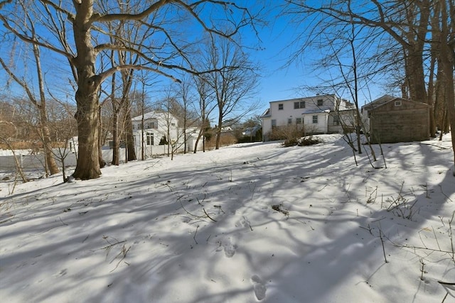 yard covered in snow with a storage unit and an outdoor structure