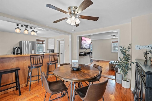 dining space featuring ceiling fan, light wood-style flooring, and a healthy amount of sunlight