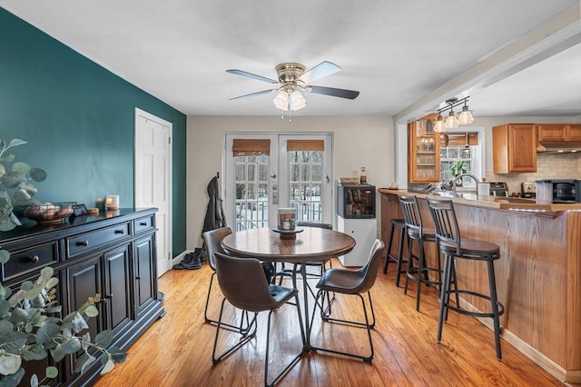 dining area featuring plenty of natural light, light wood-style flooring, and french doors