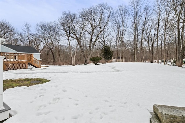 yard covered in snow with a wooden deck