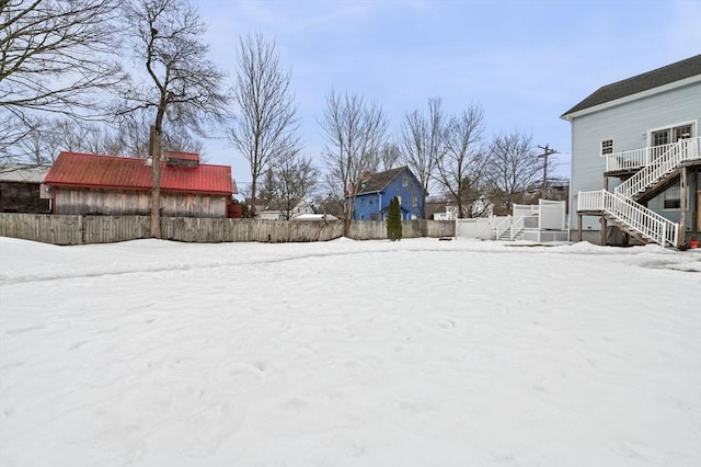 snowy yard with fence and stairs