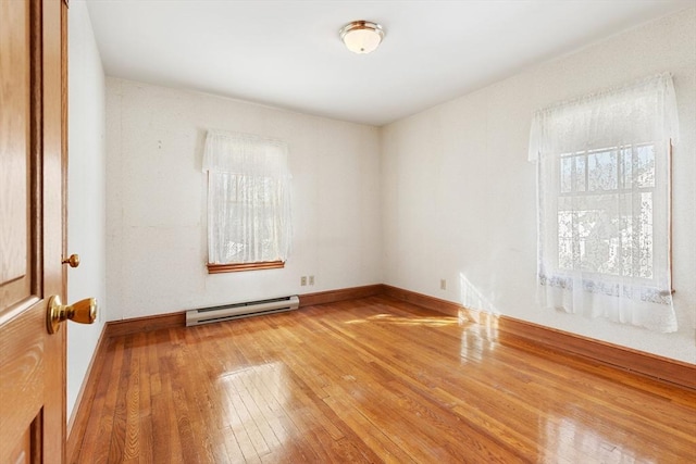 empty room featuring a baseboard radiator and hardwood / wood-style floors