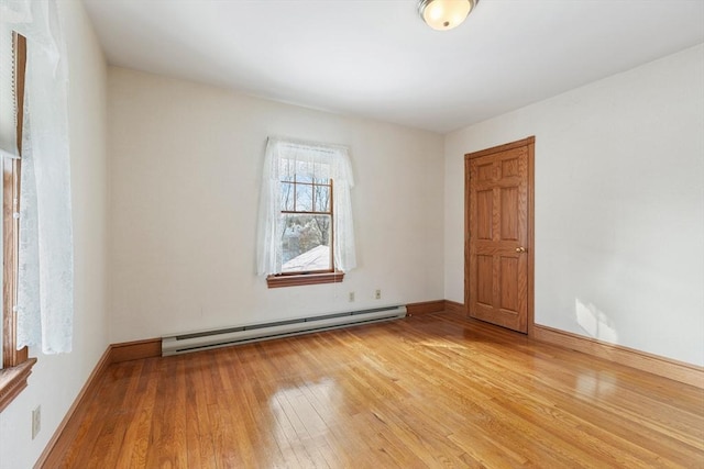 unfurnished room with a baseboard radiator and light wood-type flooring