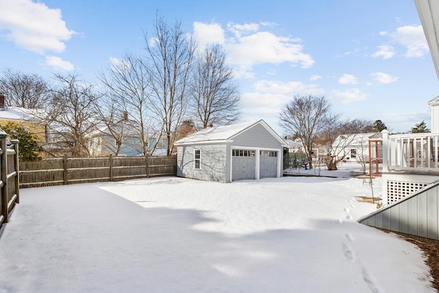 yard layered in snow featuring a garage and an outdoor structure