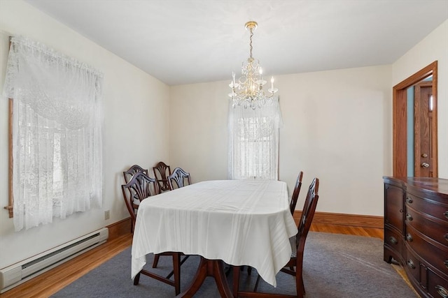 dining space featuring a baseboard radiator, dark wood-type flooring, and an inviting chandelier