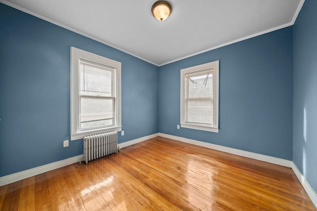 unfurnished room with radiator heating unit, baseboards, wood-type flooring, and ornamental molding