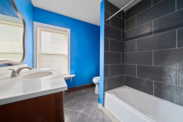 full bath featuring tile patterned flooring, toilet, vanity, bathing tub / shower combination, and baseboards