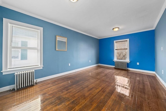 spare room with ornamental molding, radiator heating unit, and wood-type flooring