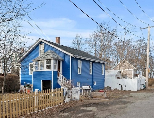 exterior space featuring a chimney and fence