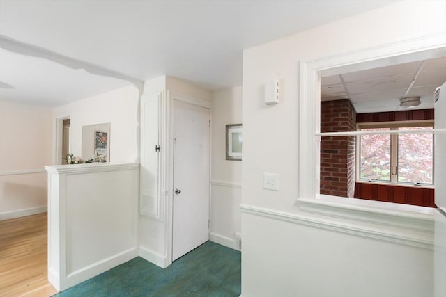 hall featuring baseboards and wood finished floors