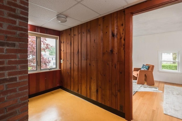 empty room with wood finished floors and wooden walls