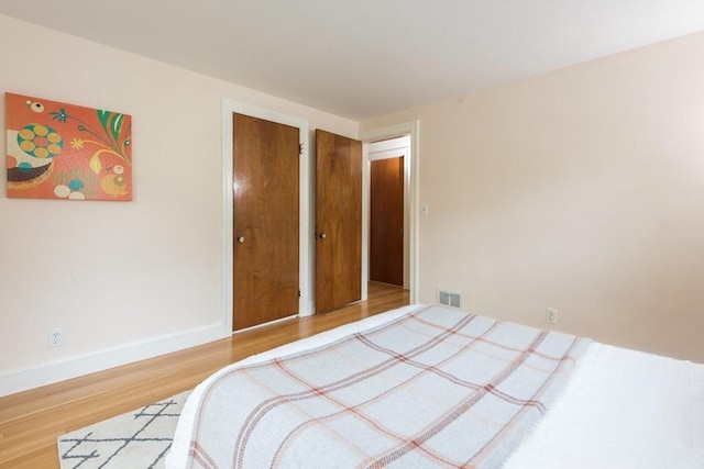 bedroom with wood finished floors and baseboards