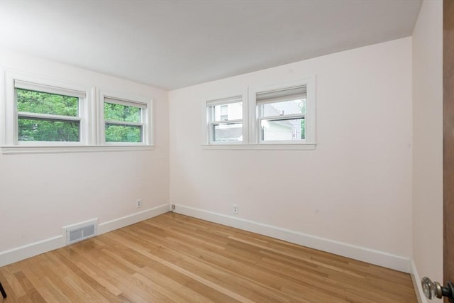 unfurnished room with baseboards, plenty of natural light, and light wood finished floors