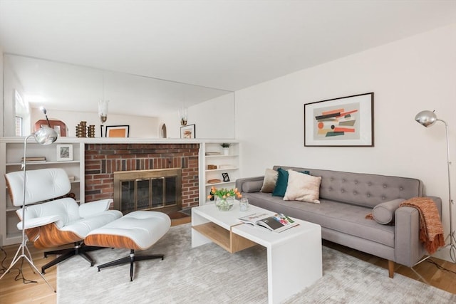 living room with wood finished floors and a brick fireplace