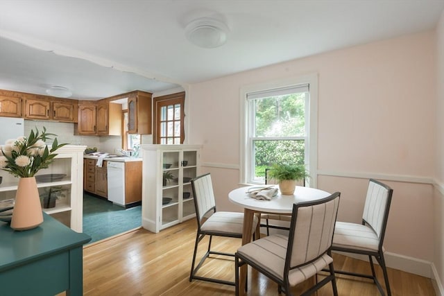 dining area with light wood finished floors and baseboards