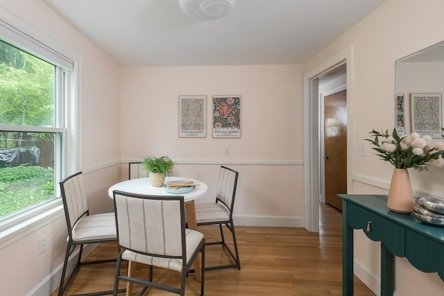 dining space featuring light wood finished floors and baseboards