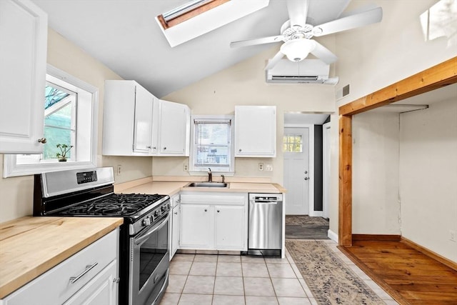 4 Morrison Way, Lakeville, MA 02347 - kitchen featuring appliances with stainless steel finishes, an AC wall unit, white cabinetry, healthy amount of natural light, and high vaulted ceiling