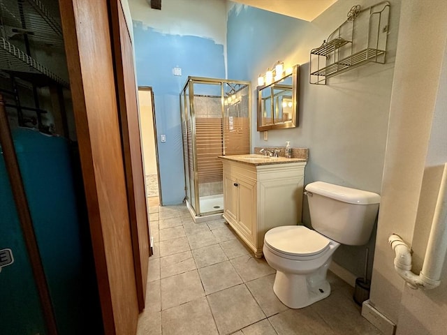 bathroom featuring tile patterned flooring, vanity, an enclosed shower, and toilet