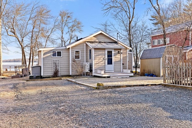 view of front of house featuring a water view and a storage shed