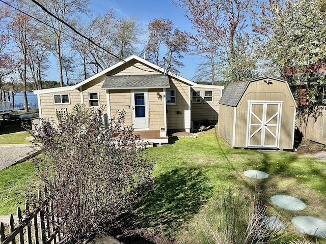 4 Morrison Way, Lakeville, MA 02347 - back of house featuring roof with shingles, a storage unit, and a lawn