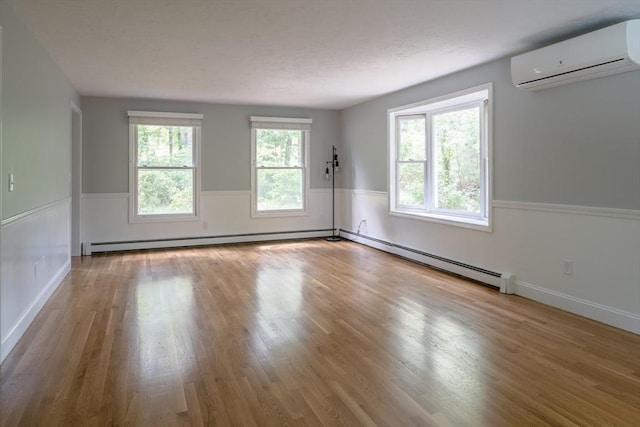 177 S St, Upton, MA 01568 - empty room with a wall mounted AC, wood finished floors, baseboard heating, a baseboard radiator, and a wainscoted wall