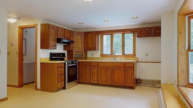 177 S St, Upton, MA 01568 - kitchen with stainless steel range oven, under cabinet range hood, brown cabinetry, a sink, and healthy amount of natural light