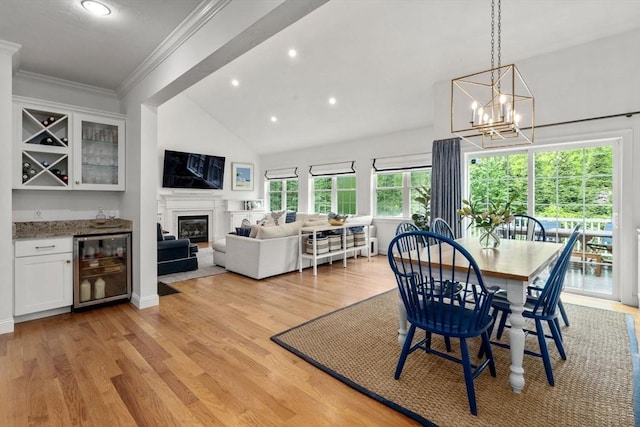 36 Village Way, Duxbury, MA 02332 - dining room featuring beverage cooler, crown molding, light wood-type flooring, a chandelier, and lofted ceiling