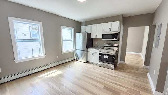97-99 Blaisdell St Unit 3, Haverhill, MA 01832 - kitchen featuring appliances with stainless steel finishes, baseboard heating, white cabinetry, and light wood-style floors