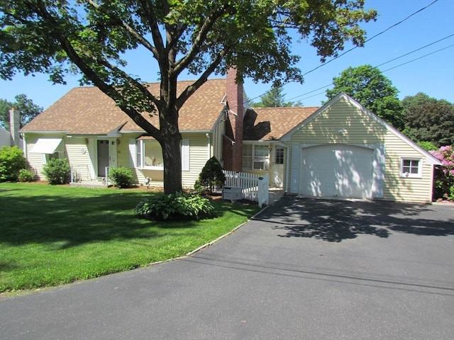 82 Laroche St, Ludlow, MA 01056 - view of front facade with asphalt driveway, a chimney, a front yard, a garage, and a shingled roof