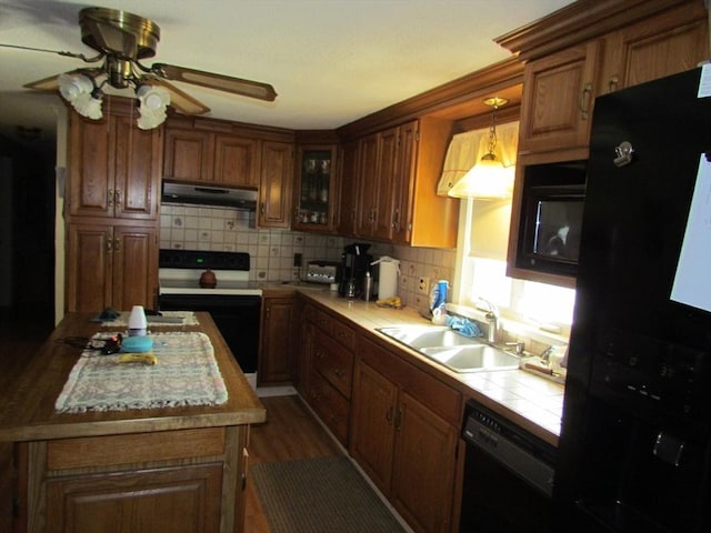 82 Laroche St, Ludlow, MA 01056 - kitchen featuring black appliances, under cabinet range hood, a sink, tile countertops, and backsplash