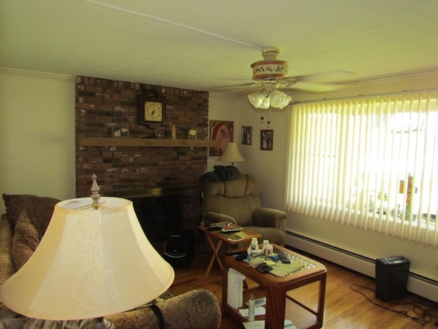 82 Laroche St, Ludlow, MA 01056 - living area with crown molding, ceiling fan, baseboard heating, a brick fireplace, and wood finished floors