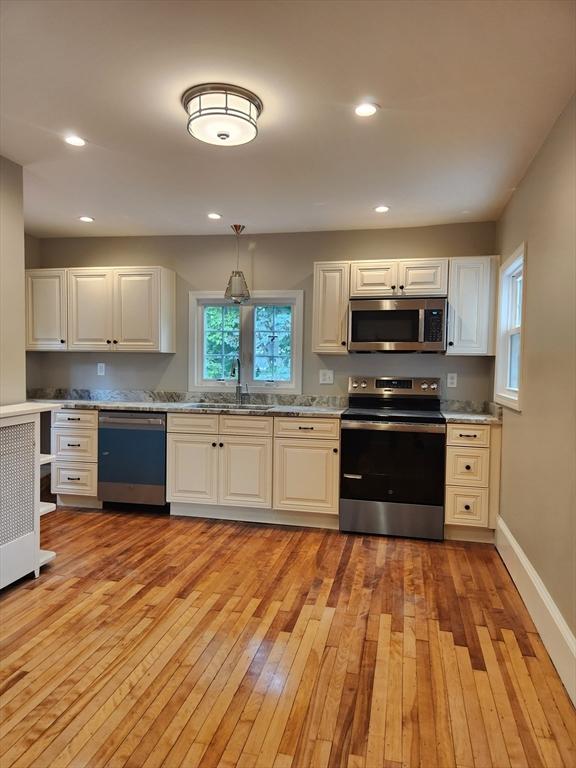 9 Varney St, Worcester, MA 01605 - kitchen featuring stainless steel appliances, light wood finished floors, recessed lighting, pendant lighting, and white cabinetry