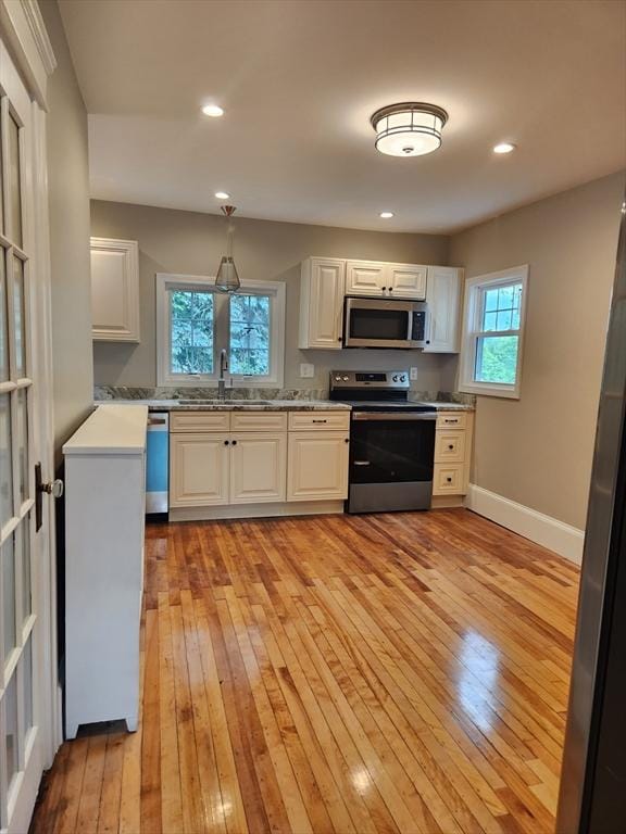 9 Varney St, Worcester, MA 01605 - kitchen with appliances with stainless steel finishes, light wood finished floors, white cabinets, and recessed lighting