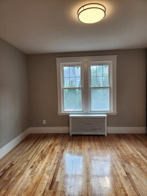 9 Varney St, Worcester, MA 01605 - empty room with radiator heating unit and light wood finished floors
