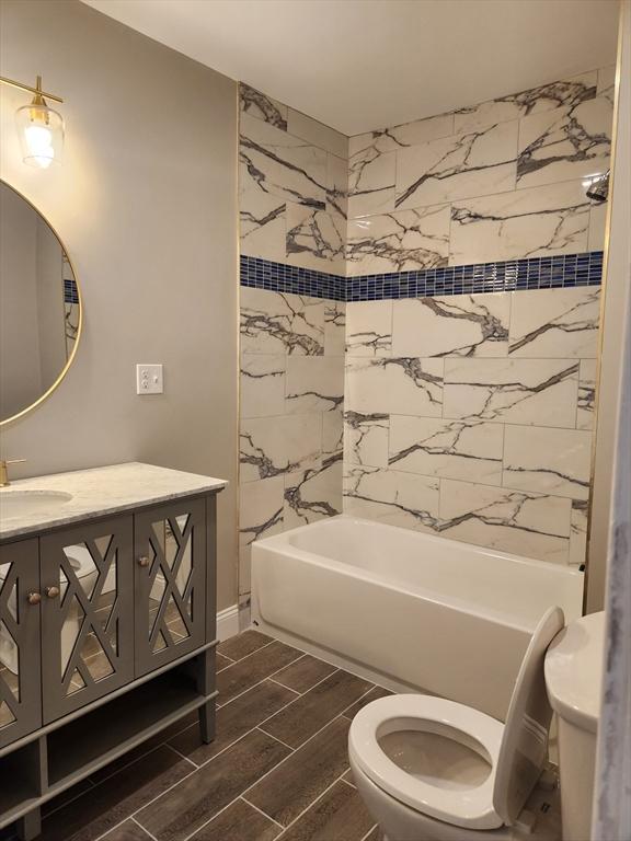 9 Varney St, Worcester, MA 01605 - bathroom featuring wood tiled floors, vanity, and washtub / shower combination