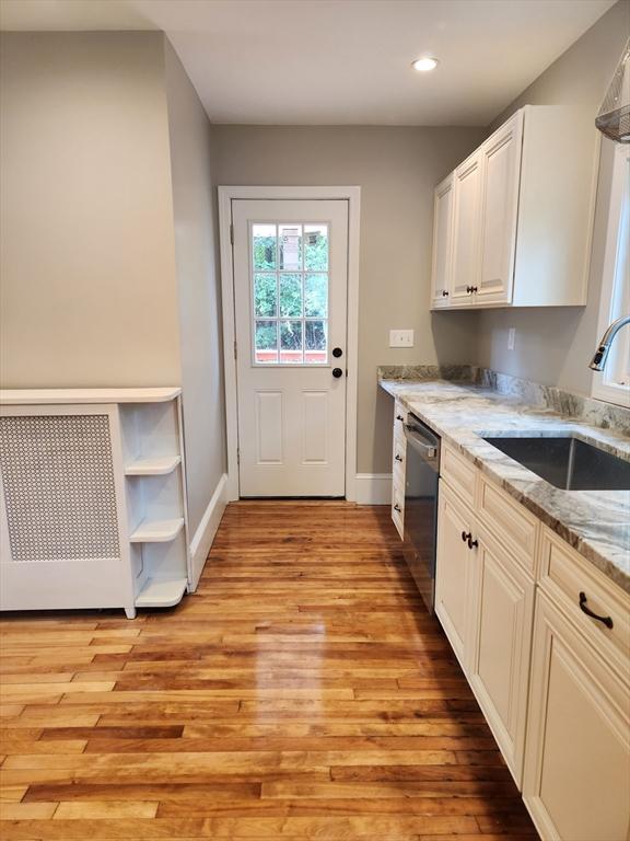 9 Varney St, Worcester, MA 01605 - kitchen featuring stainless steel dishwasher, light wood-style flooring, light stone countertops, recessed lighting, and white cabinetry