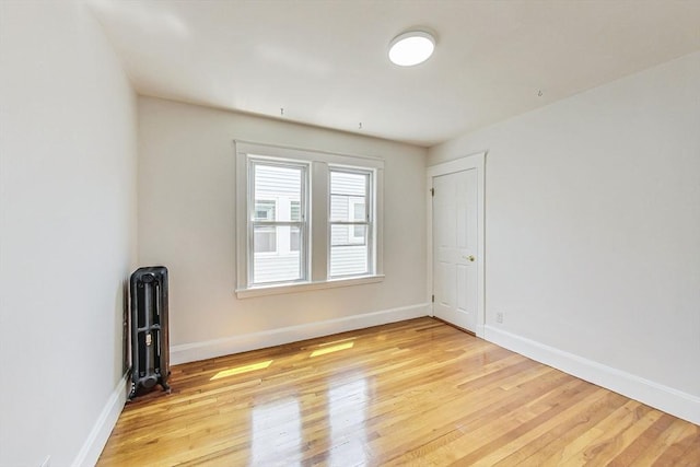 empty room with radiator and light hardwood / wood-style floors