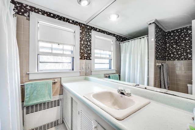 25 First Ave, Wellfleet, MA 02667 - bathroom with wallpapered walls, tile walls, ornamental molding, vanity, and radiator