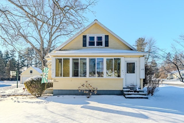 bungalow-style house featuring a garage and an outbuilding