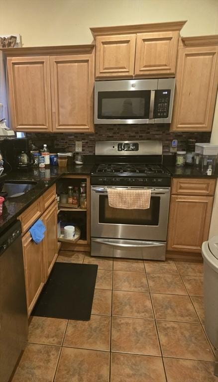 88 Esmond St, Boston, MA 02121 - kitchen featuring appliances with stainless steel finishes, dark countertops, backsplash, a sink, and light tile patterned floors