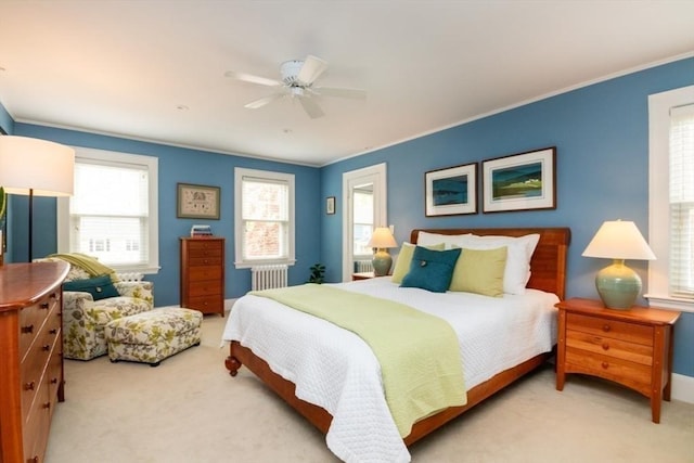 bedroom featuring crown molding, ceiling fan, radiator heating unit, and carpet