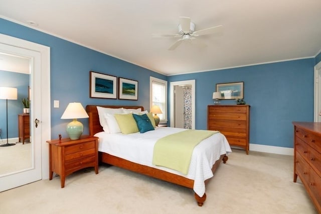 bedroom featuring crown molding, baseboards, ceiling fan, and light colored carpet