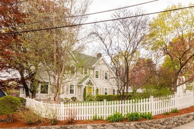 view of front facade with a fenced front yard and a chimney
