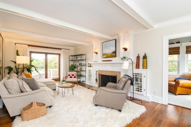 living room featuring beamed ceiling, plenty of natural light, wood finished floors, and a high end fireplace